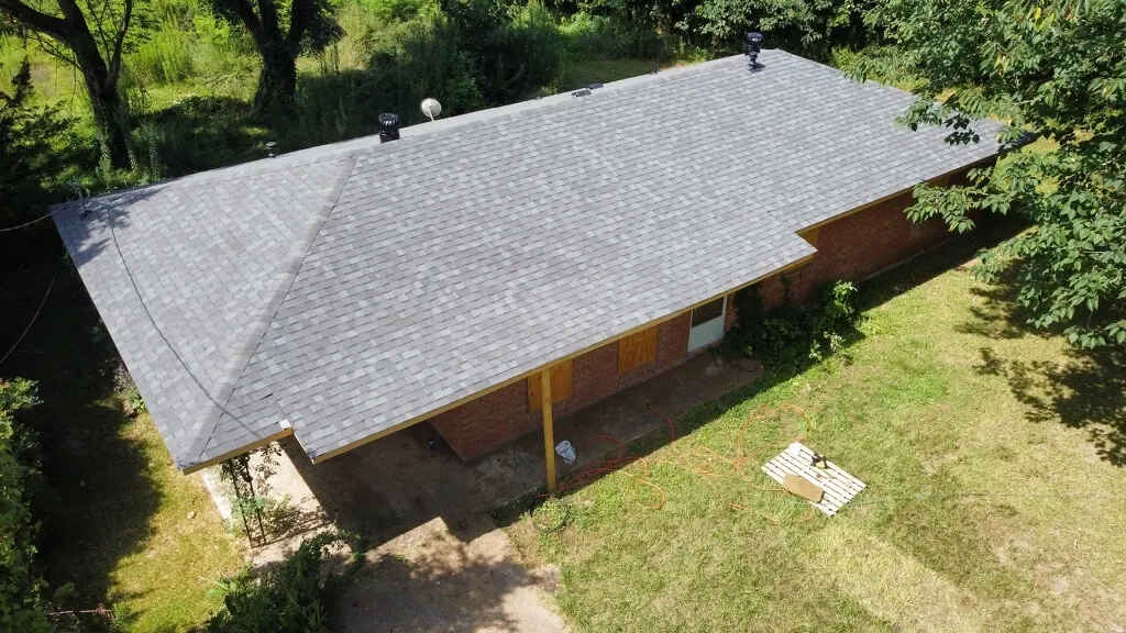 Aerial view of a finished gray shingle roof on a brick home
