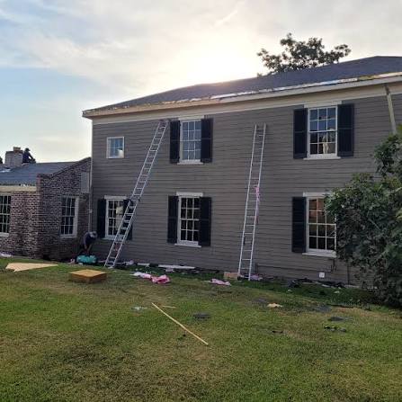 Ladders and roofing work at a two-story home