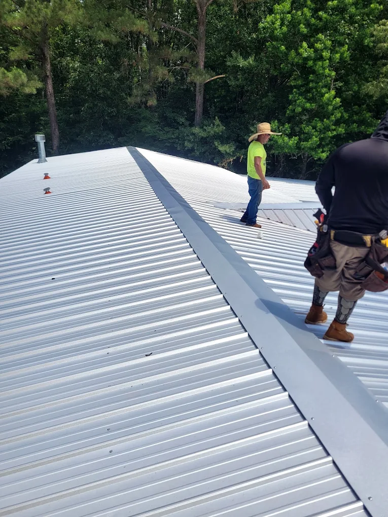 Two roofers installing a bright metal roof